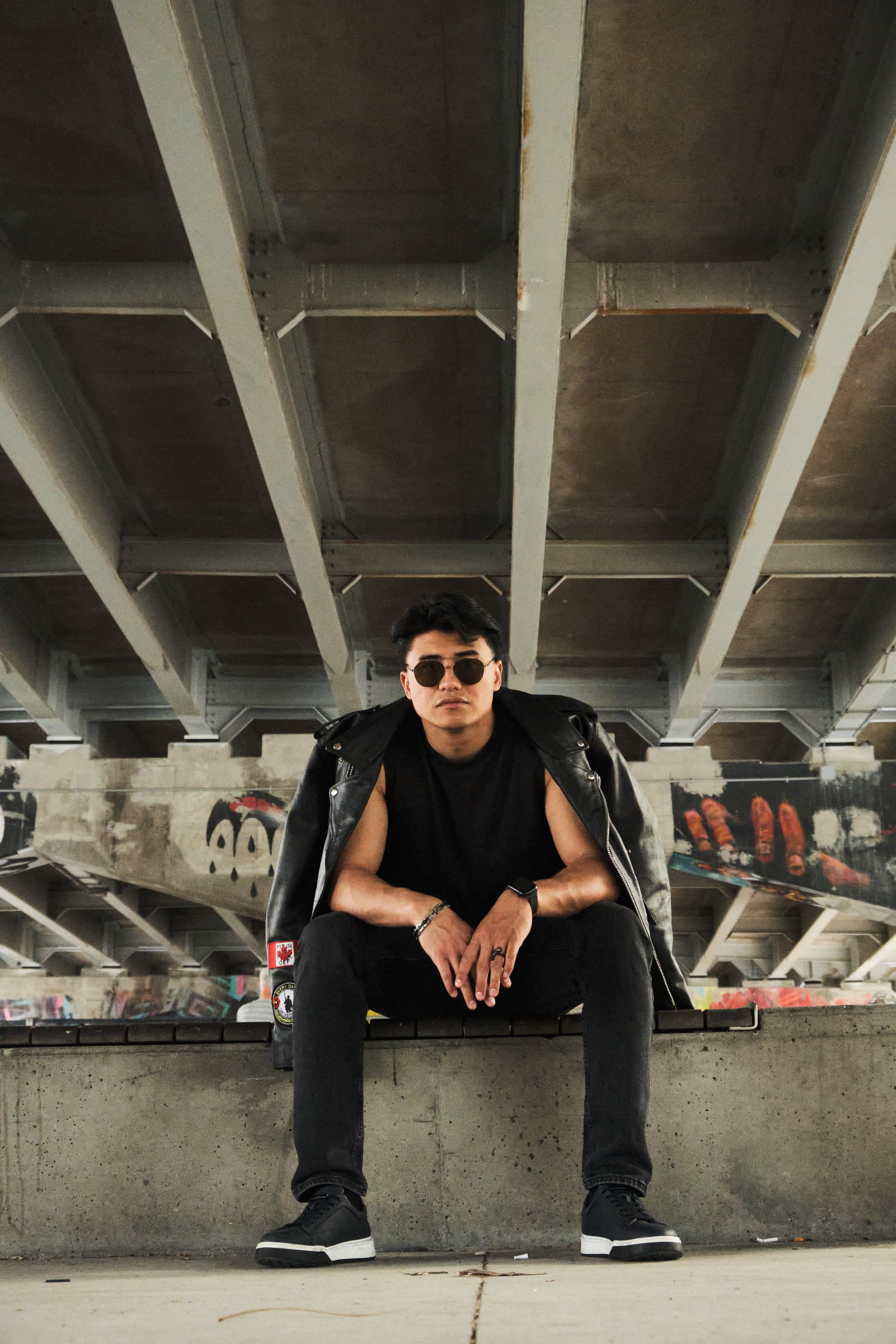 Seated portrait under a bridge