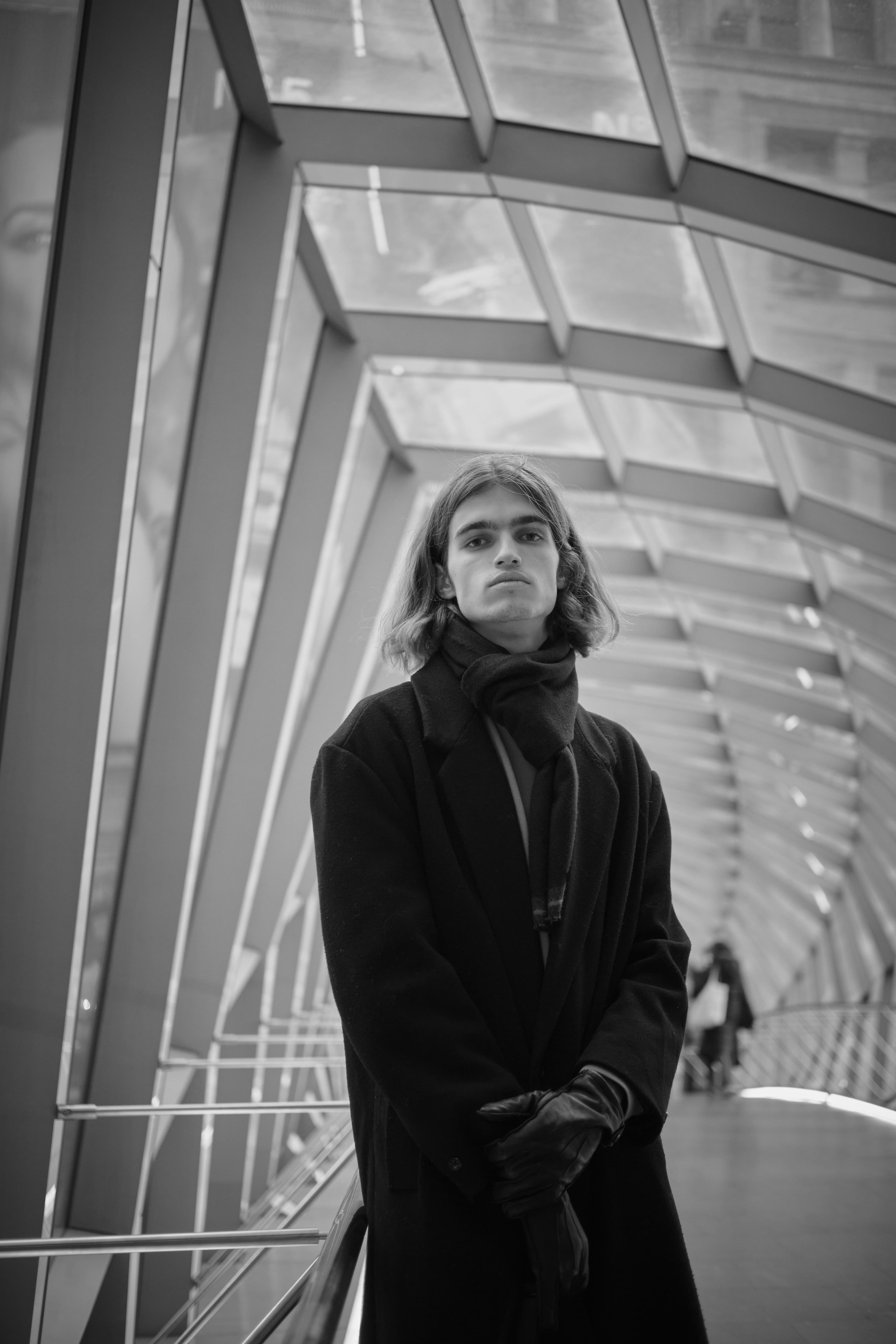 Black and white portrait in a glass passage